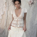 Amélie · Top peplum de encaje translúcido con escote pronunciado